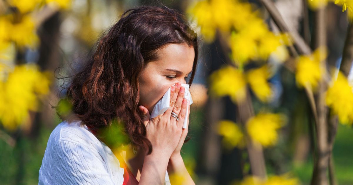 Woman blowing her nose in spring